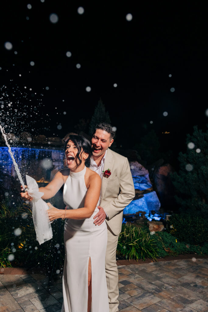 Dara and Bryan spray champagne